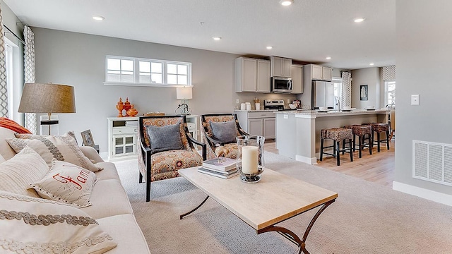 living room with sink and light wood-type flooring