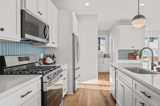 371 Liberty Dr, Hanover, MN 55341 - kitchen with a sink, light wood finished floors, white cabinets, and appliances with stainless steel finishes