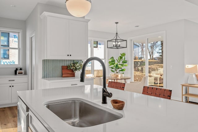 371 Liberty Dr, Hanover, MN 55341 - kitchen featuring a sink, decorative light fixtures, white cabinetry, and light wood-type flooring
