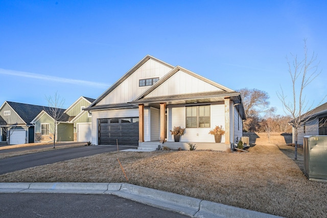 371 Liberty Dr, Hanover, MN 55341 - modern inspired farmhouse featuring a porch, aphalt driveway, a garage, and board and batten siding