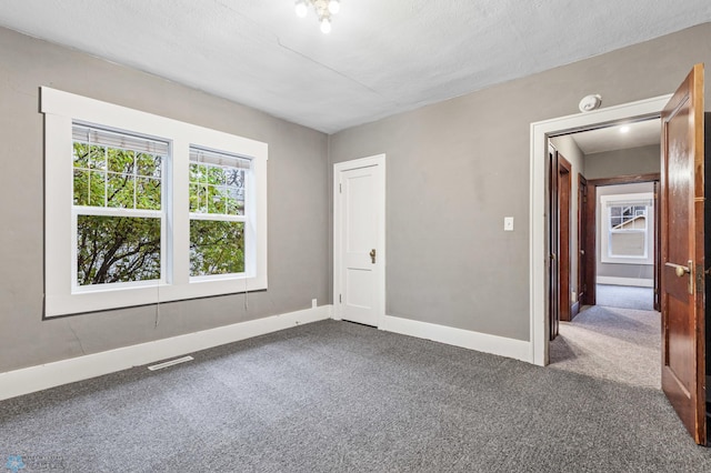 unfurnished room with a textured ceiling and carpet floors