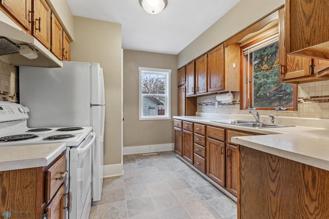 kitchen with white range with electric stovetop, sink, and tasteful backsplash