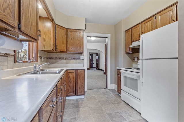 kitchen featuring tasteful backsplash, sink, and white appliances