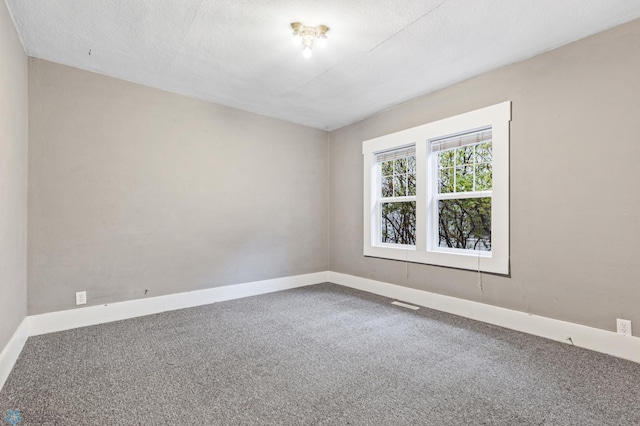 unfurnished room featuring carpet flooring and a textured ceiling