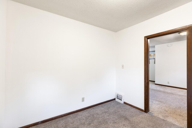 carpeted spare room with a textured ceiling