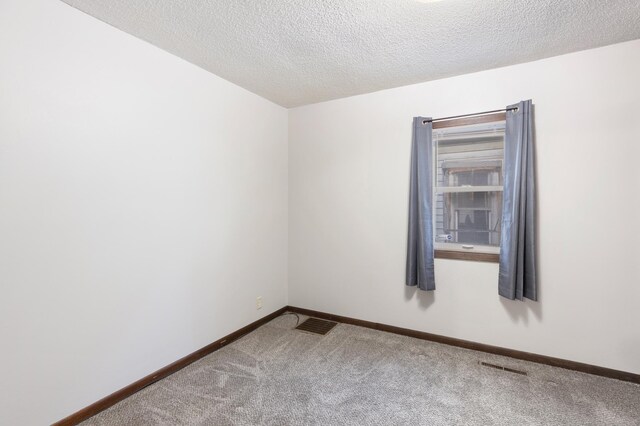 carpeted spare room with a textured ceiling