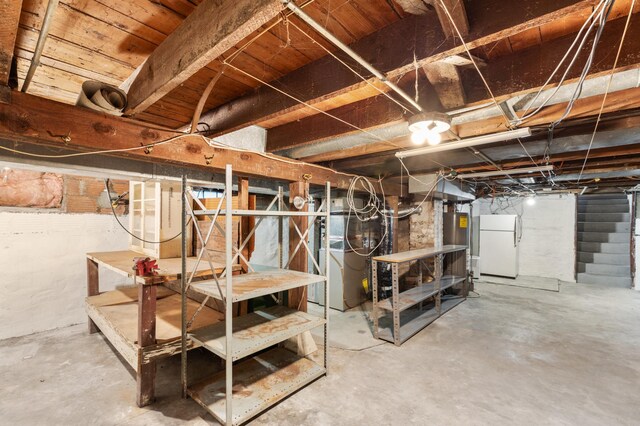 basement featuring white refrigerator and gas water heater