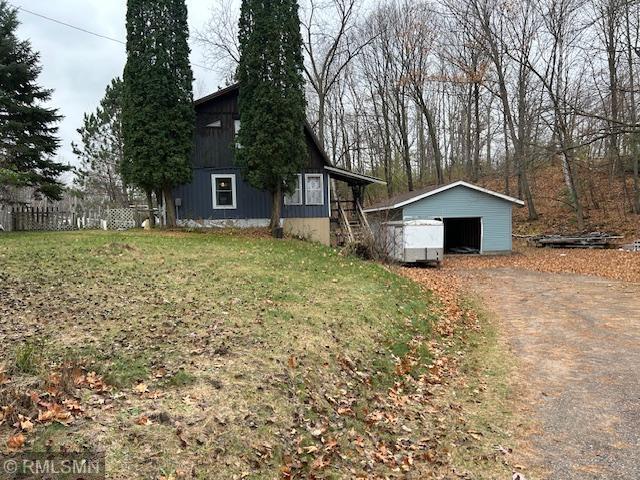 view of side of home with a yard and an outbuilding