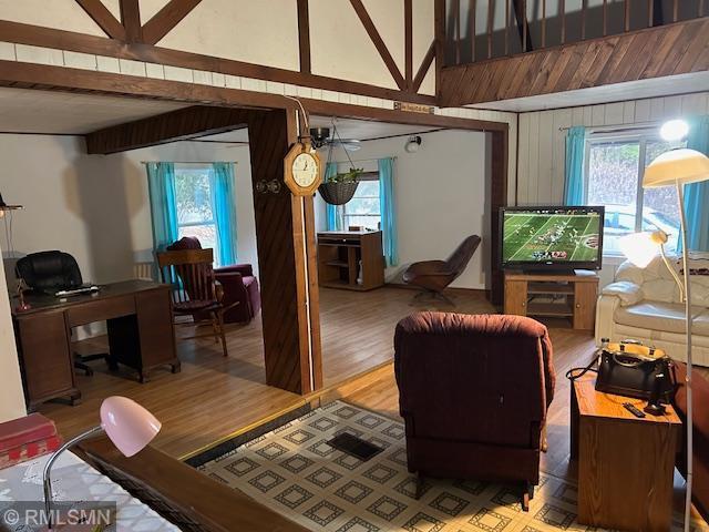 living room featuring beam ceiling and light hardwood / wood-style floors