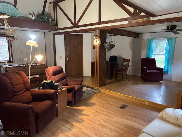 living room with ceiling fan, lofted ceiling with beams, and hardwood / wood-style floors