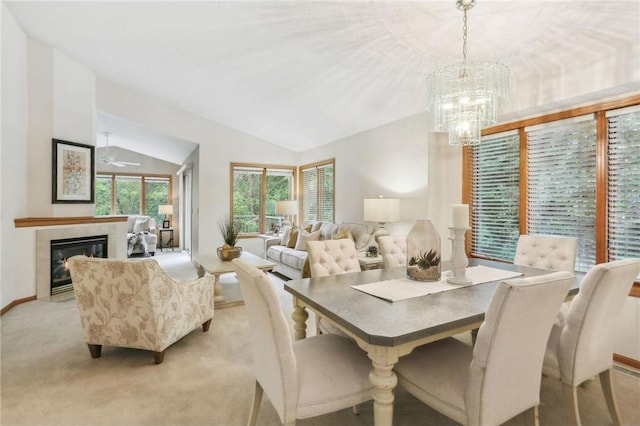 dining area with light colored carpet, a chandelier, and lofted ceiling