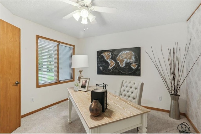 carpeted office space featuring ceiling fan and a textured ceiling