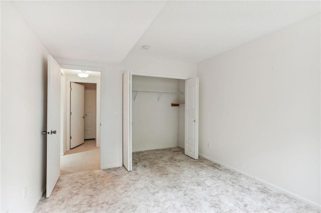 unfurnished bedroom featuring a closet and light colored carpet