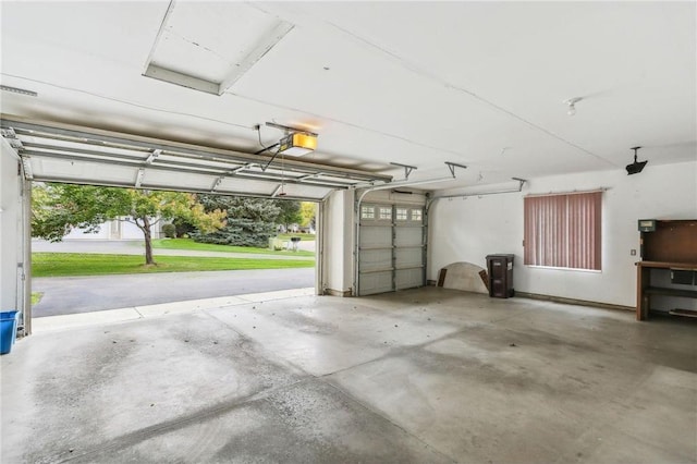 garage featuring a garage door opener and a lawn