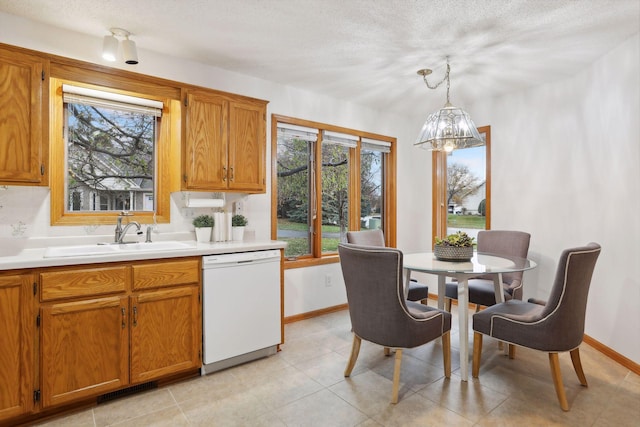 kitchen featuring pendant lighting, a wealth of natural light, sink, and white dishwasher