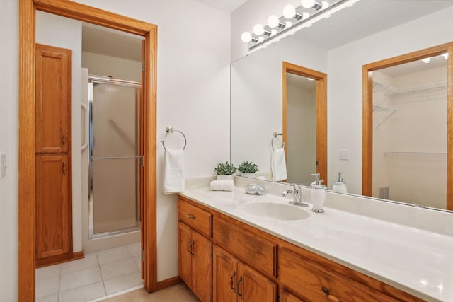 bathroom featuring tile patterned floors, vanity, and a shower with door