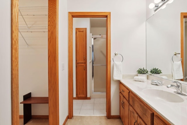 bathroom with tile patterned flooring, vanity, and an enclosed shower