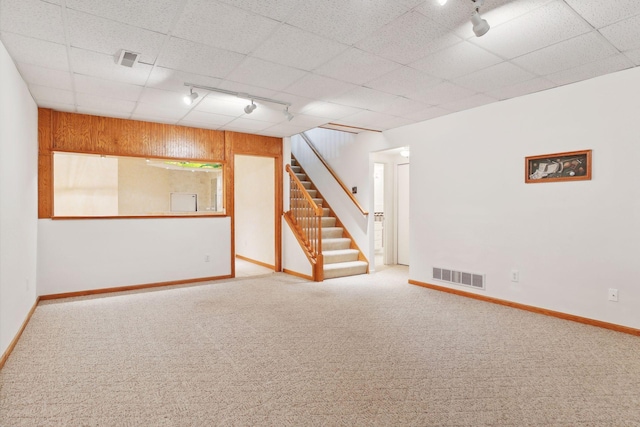 basement featuring carpet floors and rail lighting