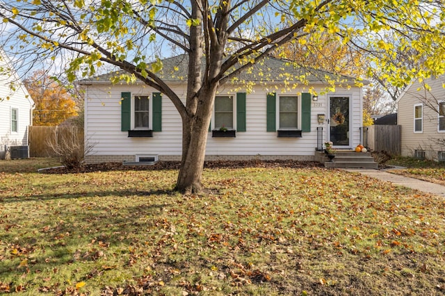 view of front facade with a front lawn and central air condition unit