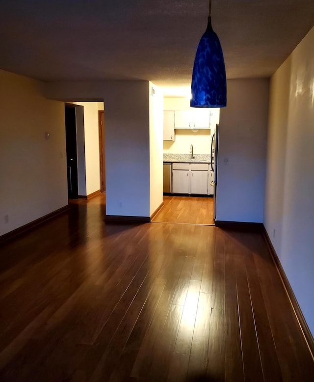 unfurnished living room with hardwood / wood-style floors and sink