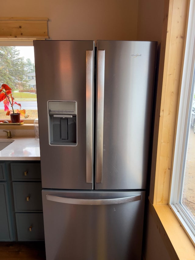 kitchen featuring gray cabinets and stainless steel refrigerator with ice dispenser