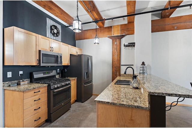 kitchen featuring light stone countertops, appliances with stainless steel finishes, sink, and hanging light fixtures