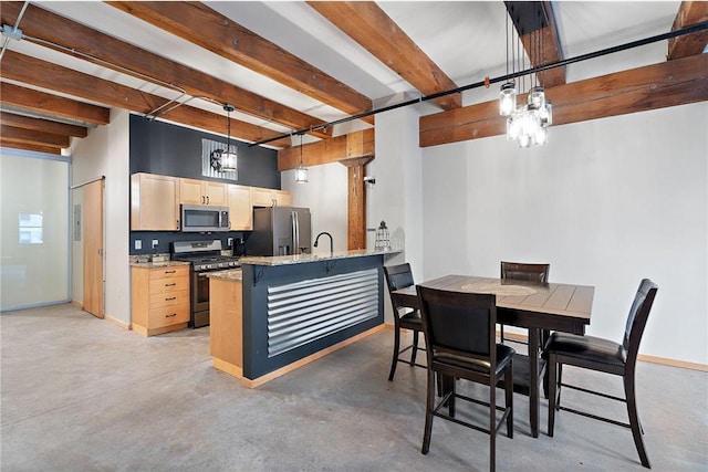 kitchen with beamed ceiling, kitchen peninsula, appliances with stainless steel finishes, light brown cabinets, and decorative light fixtures