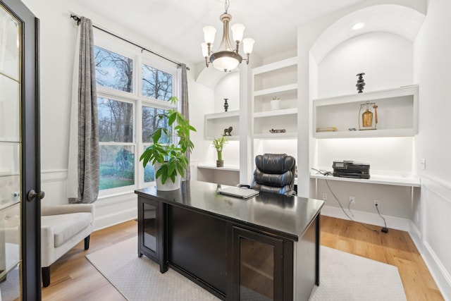 office area featuring a notable chandelier, a healthy amount of sunlight, and light hardwood / wood-style flooring