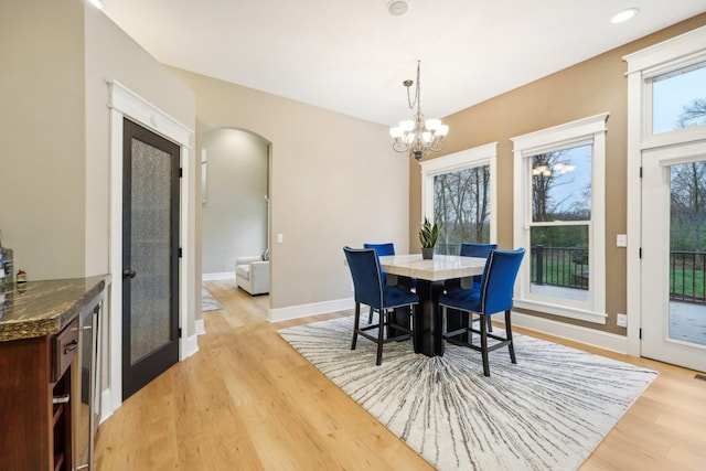 dining area with light wood-type flooring and a chandelier