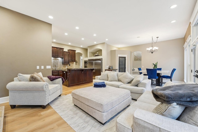 living room with a notable chandelier and light hardwood / wood-style flooring