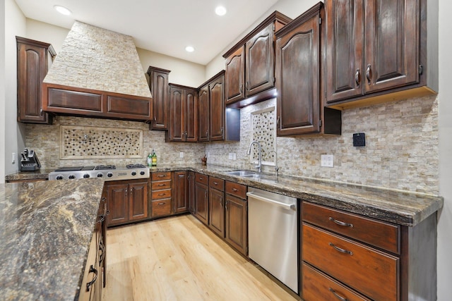 kitchen featuring tasteful backsplash, custom range hood, light hardwood / wood-style floors, and stainless steel appliances