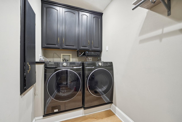 washroom featuring light hardwood / wood-style floors, cabinets, and independent washer and dryer