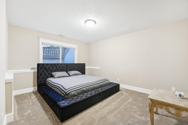 carpeted bedroom featuring a textured ceiling