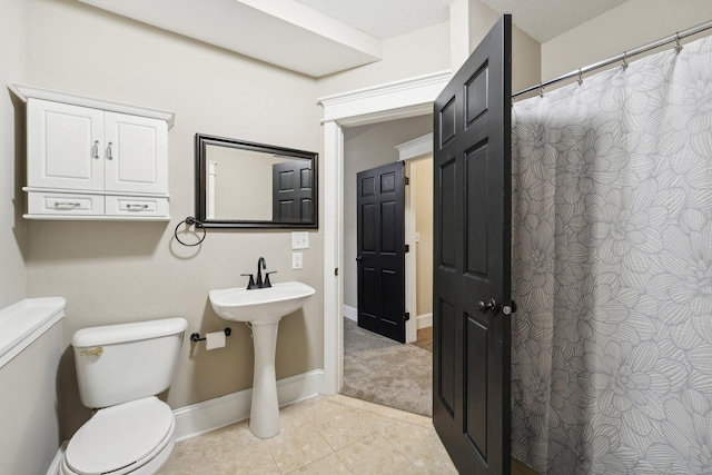 bathroom with toilet and tile patterned flooring