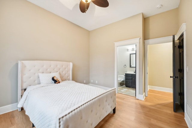 bedroom featuring ensuite bathroom, ceiling fan, and light wood-type flooring