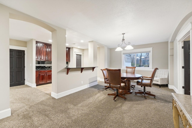 dining area with light colored carpet and a notable chandelier