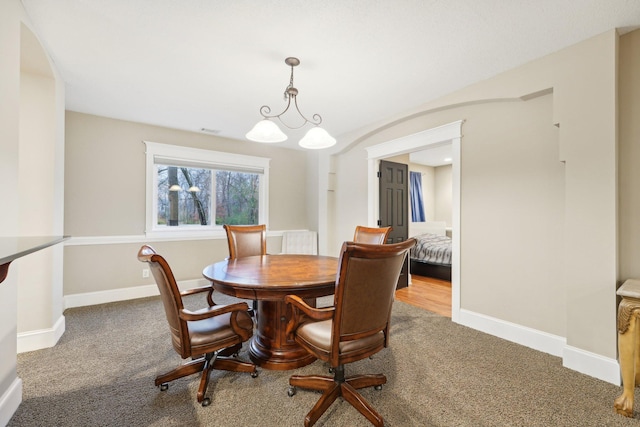 dining space featuring a chandelier and carpet