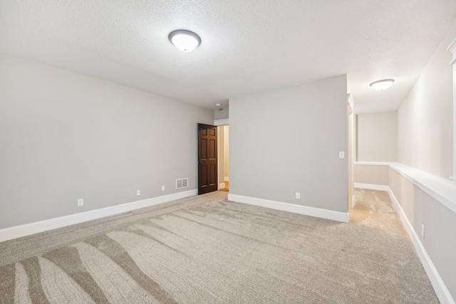 carpeted spare room with a textured ceiling