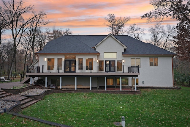 back house at dusk featuring a patio area and a yard