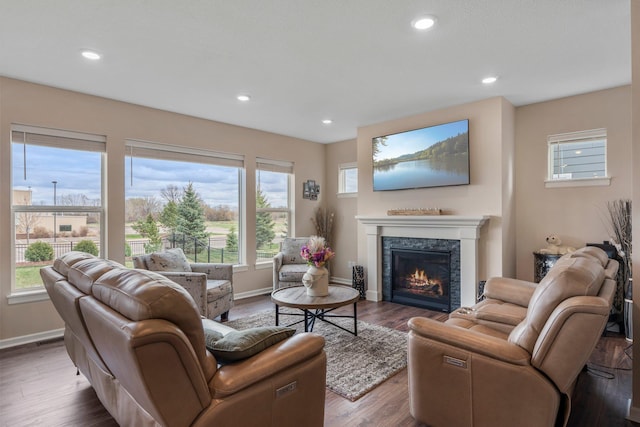 living area with baseboards, a high end fireplace, wood finished floors, and recessed lighting