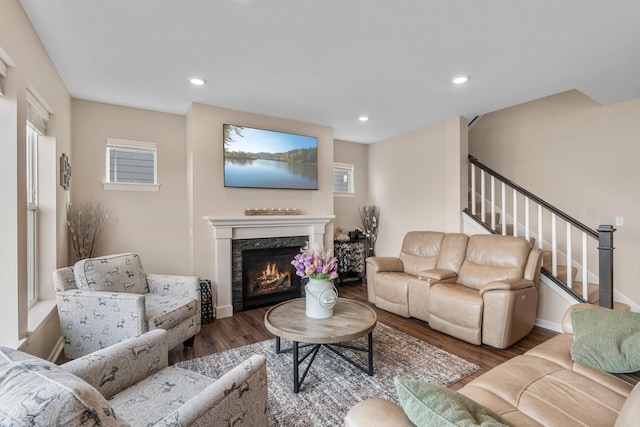 living area with stairs, recessed lighting, wood finished floors, and a fireplace