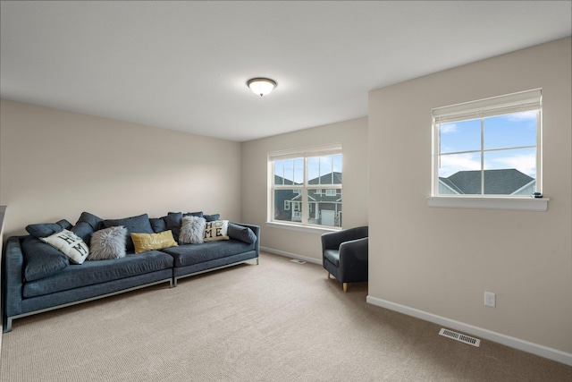 living area featuring carpet floors, baseboards, and visible vents