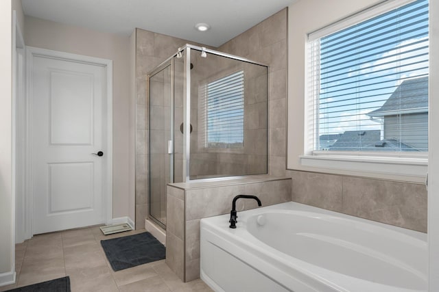 bathroom featuring tile patterned floors, a shower stall, and a bath
