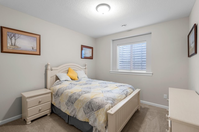carpeted bedroom with baseboards and a textured ceiling