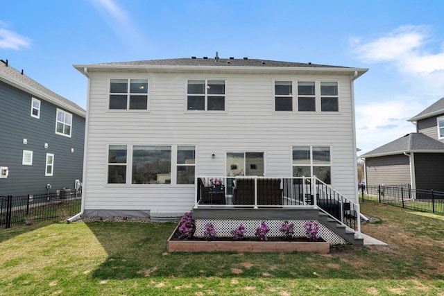 back of property with a fenced backyard, a wooden deck, and a yard