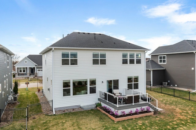 back of property with a fenced backyard, a yard, a deck, and central AC unit