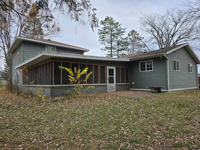 rear view of property with a sunroom and a yard