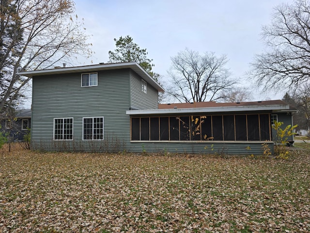 rear view of house featuring a sunroom