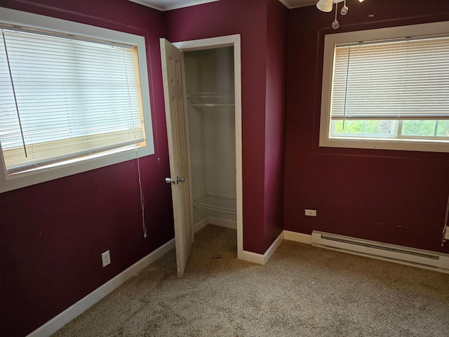 unfurnished bedroom with carpet flooring, a baseboard heating unit, and a closet