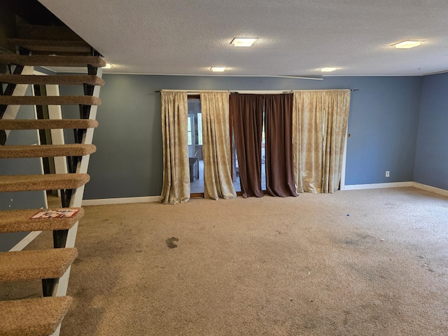 carpeted spare room with a textured ceiling